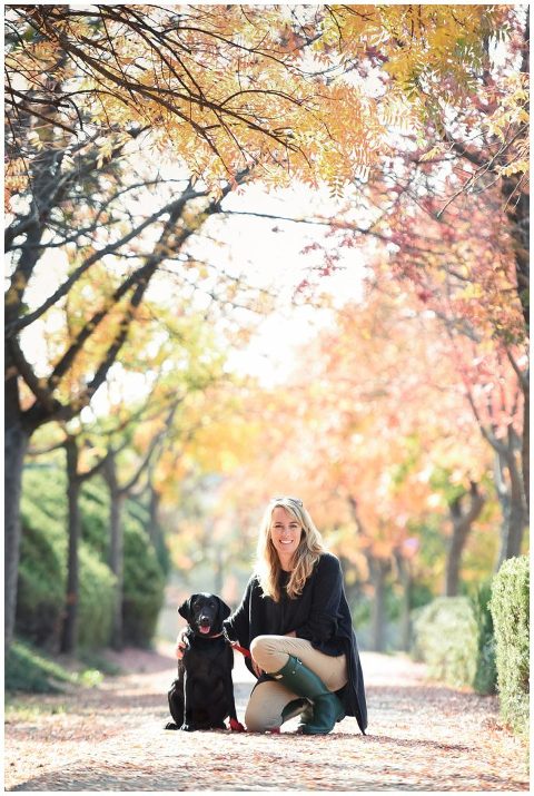 A photographer posing with her Black Lab dog. 